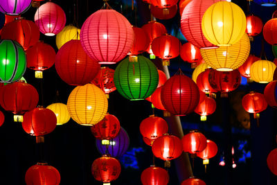 Low angle view of illuminated lanterns hanging at night