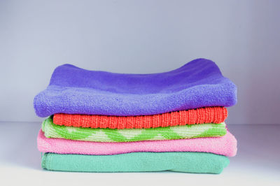 Close-up of colorful towels on table against white background