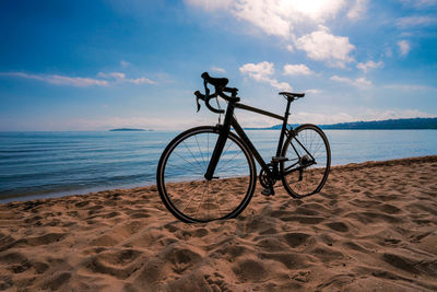 Bicycle on beach against sky