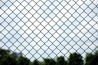 Close-up of chainlink fence against sky