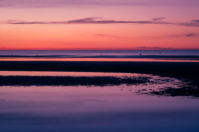 Colorful sunset at the beach with sand banks in the foreground at low tide