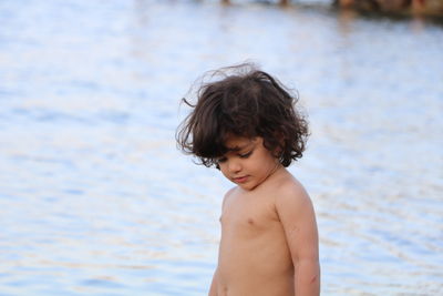 Portrait of shirtless boy against water