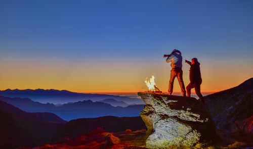 Man on mountain against clear sky during sunset