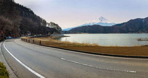 Road by lake against sky