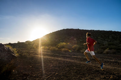 Full length of man skateboarding on mountain against sky during sunset