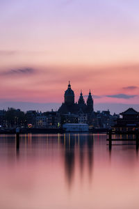 Buildings at waterfront during sunset