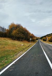 Empty road along landscape and against sky