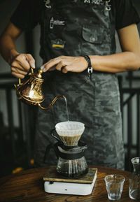 Midsection of man preparing food in glass