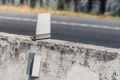 Close-up of arrow symbol on road against wall