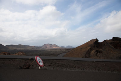 Road by mountains against sky