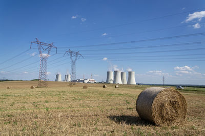 Hay bales on field against sky