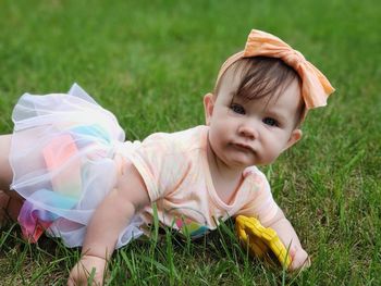 Portrait of cute baby girl on field