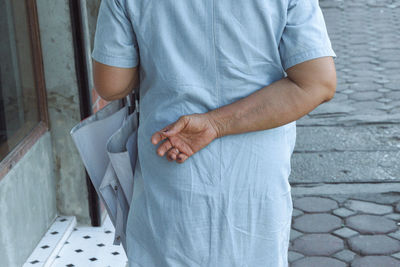 Midsection of man standing by wall