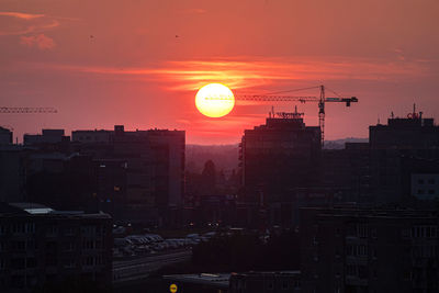 Silhouette buildings against sky during sunset