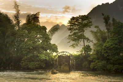 Scenic view of water wheel by river