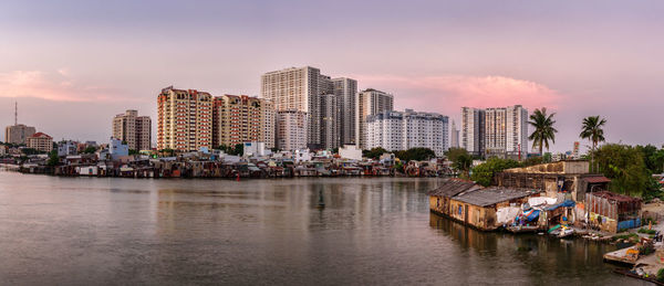 Scenic view of river by city against sky