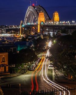 Light trails on street amidst buildings in city at night