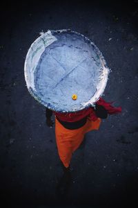 High angle view of man walking with flower in basket on head 