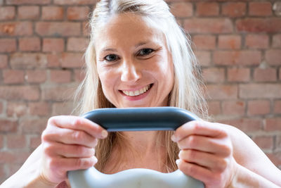 Portrait of smiling young woman holding food at home