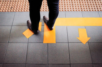 Low section of woman standing on tiled floor