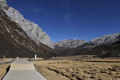 Scenic view of landscape and mountains against blue sky
