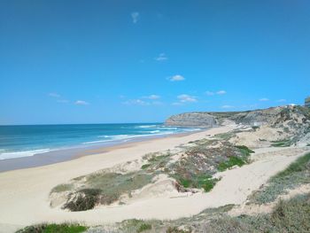 Scenic view of beach against blue sky