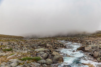 Scenic view of waterfall against sky