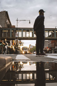 Rear view of man standing on street in city
