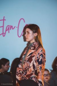 Portrait of young woman looking away against sky