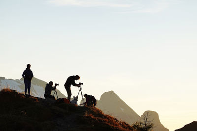 People on mountain against sky