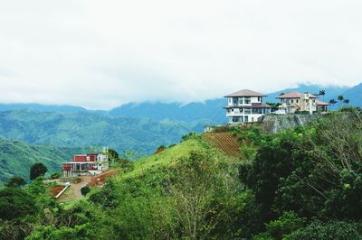 Houses on mountain against sky