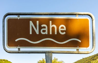 Low angle view of road sign against clear sky