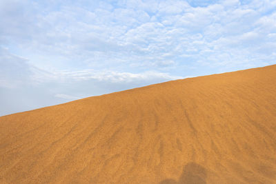 Sand dunes in desert against sky