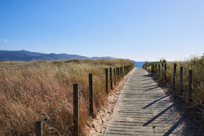 Wooden fence on field against clear sky