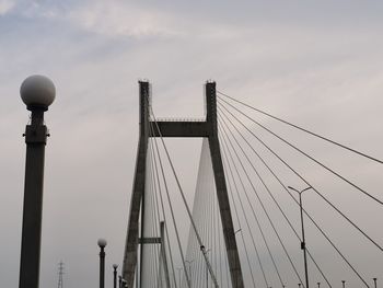 Low angle view of bridge against cloudy sky