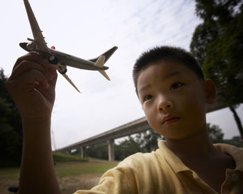 Boy playing with model airplane at park