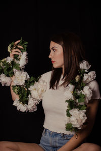 Woman holding flower bouquet against black background