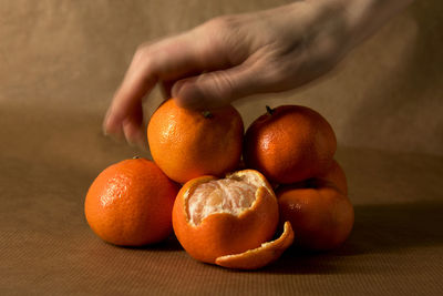 Cropped hand holding orange fruit