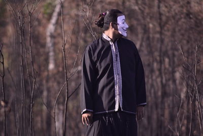 Man standing on field in forest