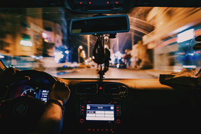 Close-up of man driving car at night