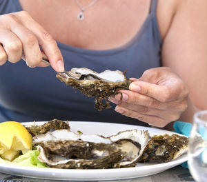 Woman eat with a fork oysters