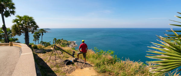 Rear view of man by sea against sky