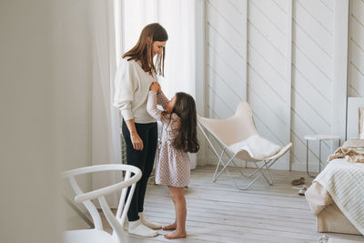 Woman standing against wall at home