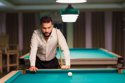 Young woman playing pool