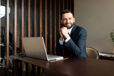 Portrait of businessman sitting at desk in office cabin