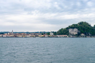 Sea by townscape against sky