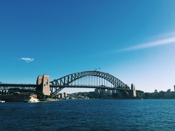 Sydney harbor bridge over river against sky