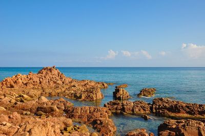 Scenic view of rocks on beach against sky