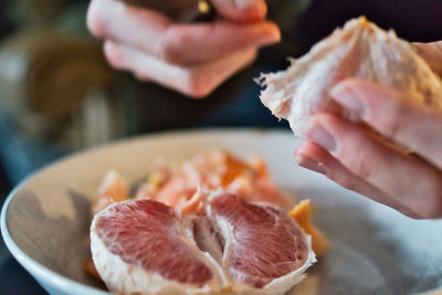 Close-up of hand holding ice cream in plate
