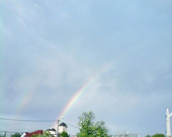 Low angle view of rainbow over trees